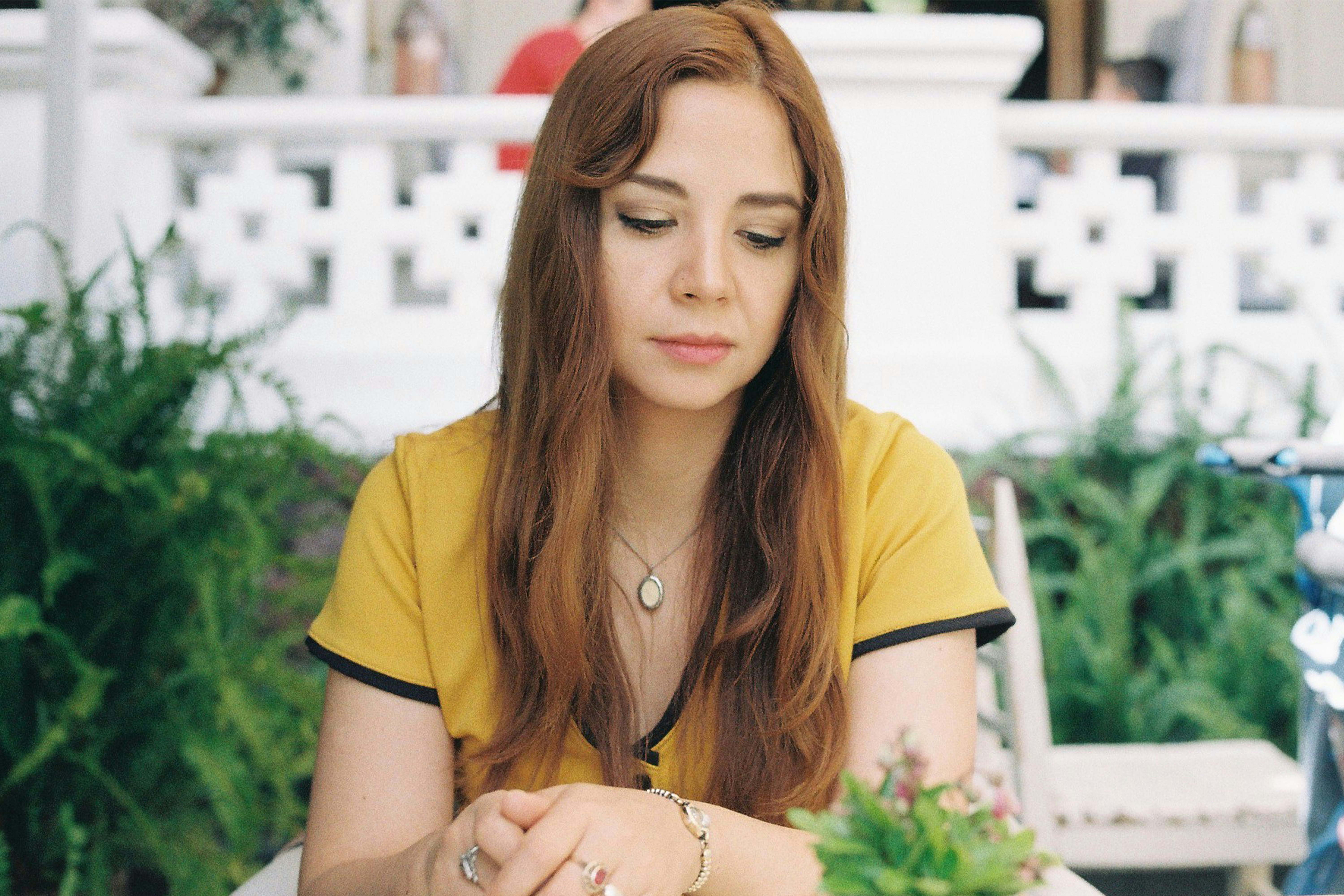 woman in yellow shirt wearing silver necklace